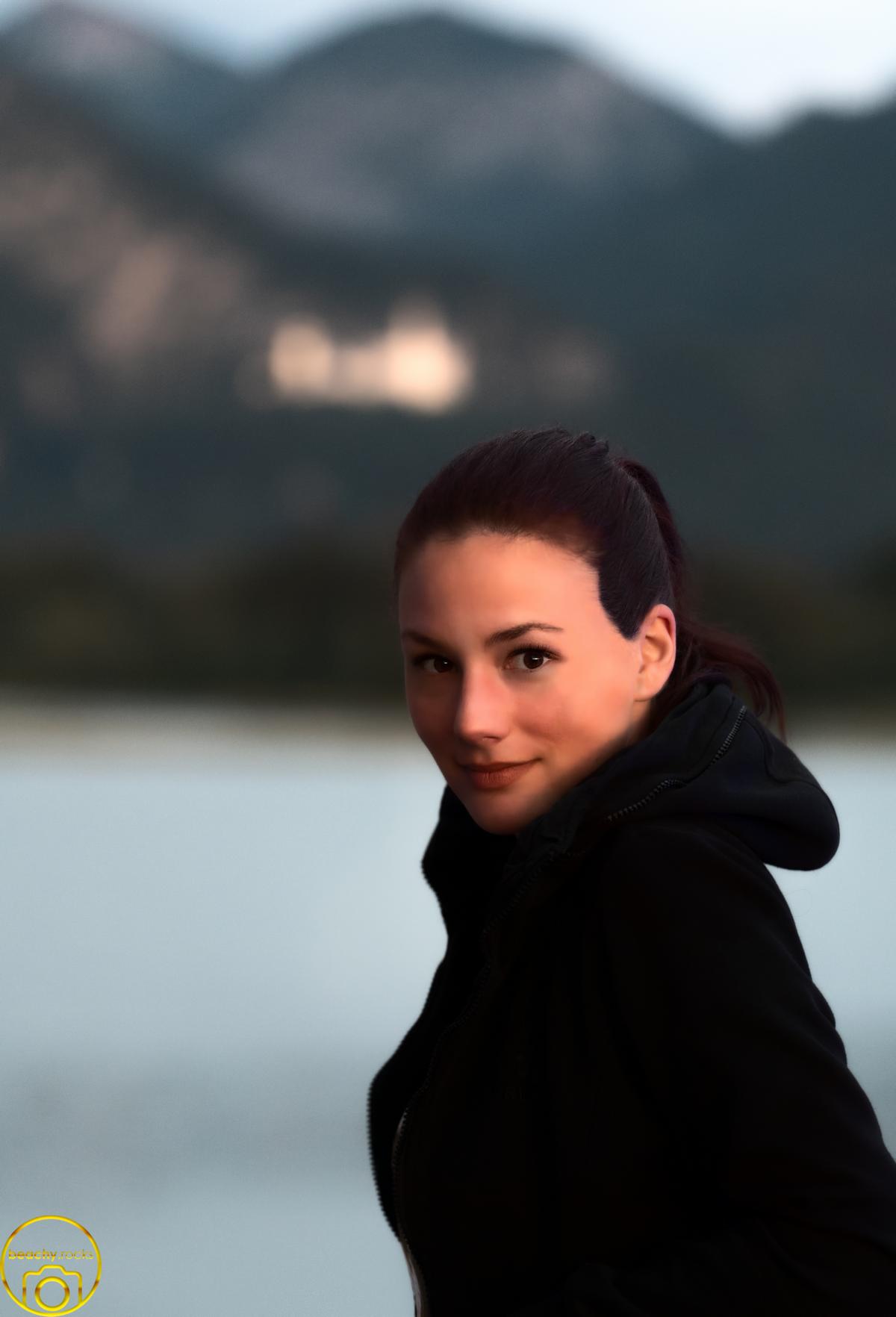 Porträt einer Frau in schwarzer Jacke vor einem Bergsee