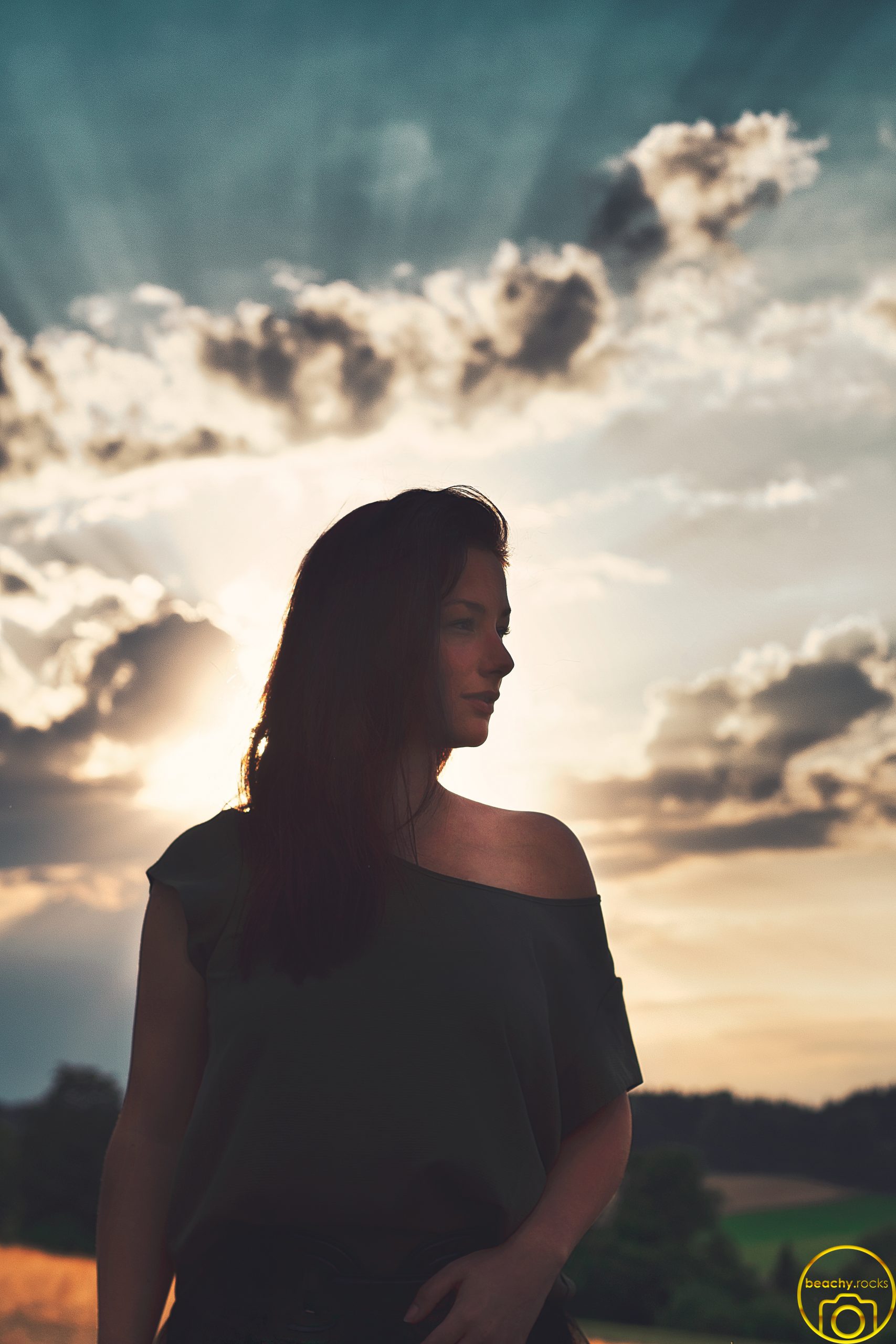Silhouette einer Frau vor dramatischem Wolkenhimmel