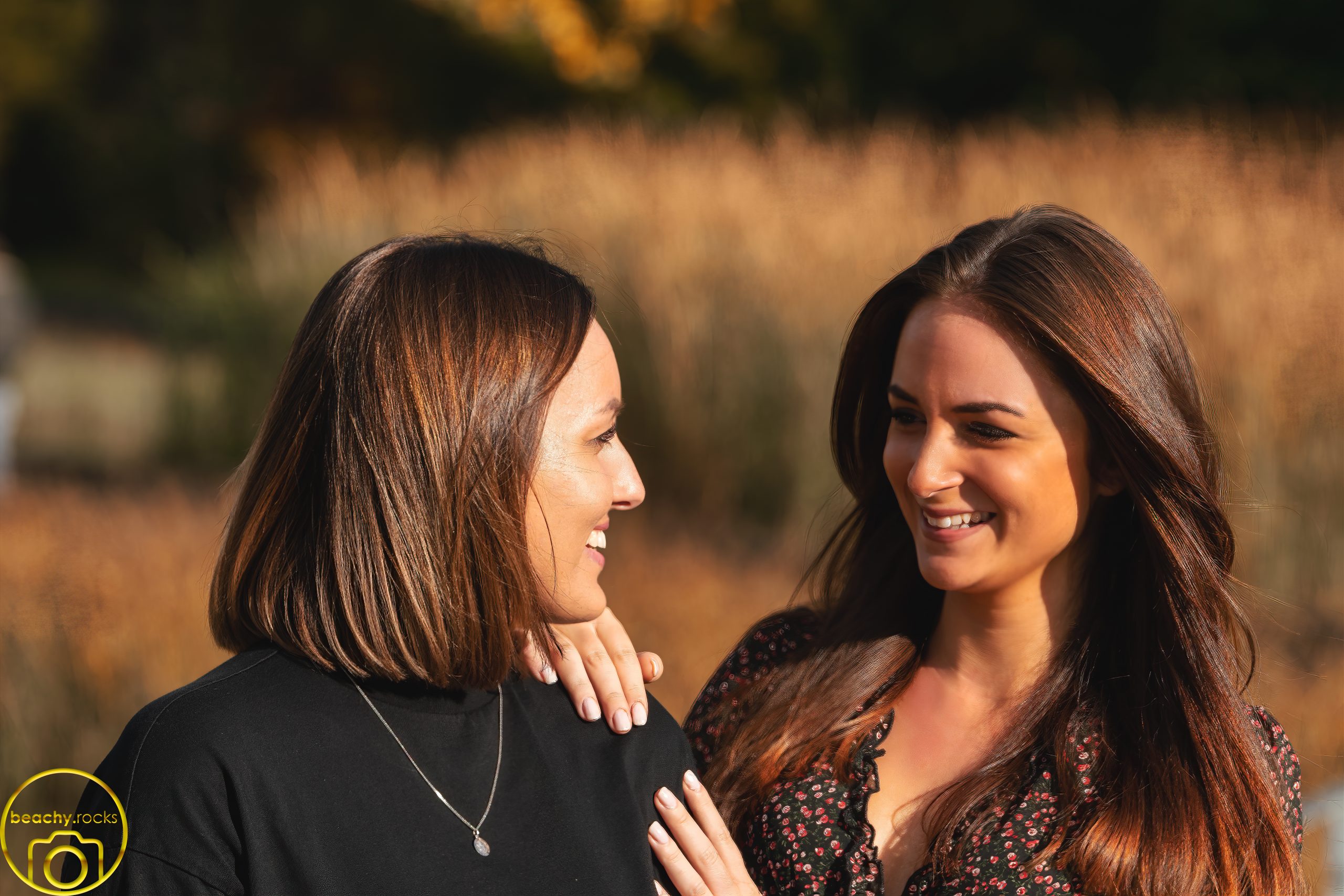 Zwei Frauen lachen gemeinsam im goldenen Abendlicht